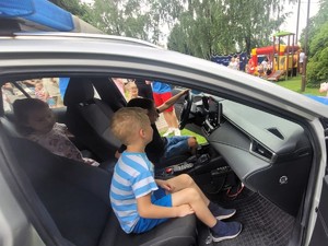 Zdjęcie przedstawia: dzieci w radiowozie.