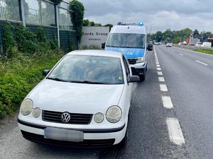 Zdjęcie przedstawia: samochód osobowy i auto policyjne.