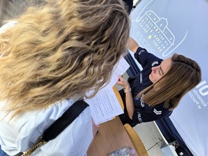 Zdjęcie przedstawia: policjantkę trzymająca kartki w rękach.