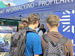 Zdjęcie przedstawia: młodych ludzi stojących przy namiocie policji.