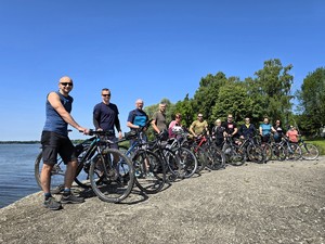 Zdjęcie przedstawia: grupę ludzi stojących obok swoich rowerów.