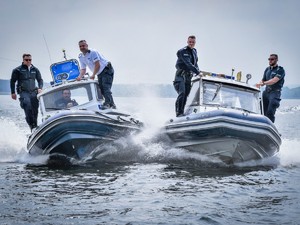 Zdjęcie przedstawia: dwie łodzie policyjnej płynące po wodzie  i umundurowanych policjantów.