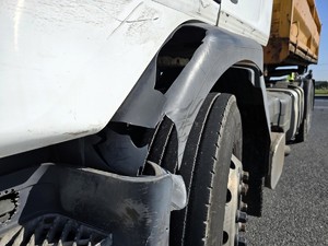 Zdjęcie przedstawia: przednią oponę auta ciężarowego.