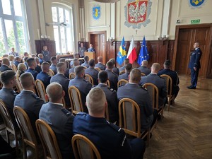 Zdjęcie przedstawia: grupę siedzących policjantów, patrzących w kierunku osoby przemawiającej.