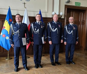 Zdjęcie przedstawia:  czerech umundurowanych policjantów stojących w szeregu.