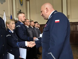 Zdjęcie przedstawia: policjanta podającego rękę policjantce.