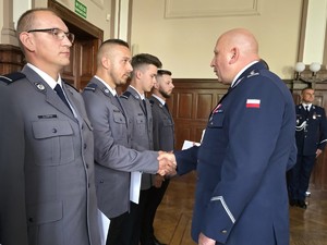 Zdjęcie przedstawia: policjanta podającego rękę drugiemu policjantowi.