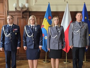 Zdjęcie przedstawia: dwie policjantki i dwóch policjantów stojących w szeregu.