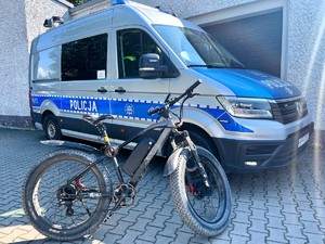 Zdjęcie przedstawia: radiowóz policyjny i rower.