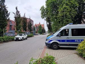 Zdjęcie przedstawia: samochód policyjny stojący przy drodze.