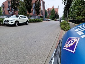 Zdjęcie przedstawia: drogę i stojące auto.