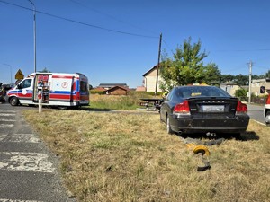 Zdjęcie przedstawia: tył samochodu biorącego udział w zdarzeniu oraz karetkę pogotowia.