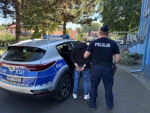 Zdjęcie. Policjant z zatrzymanym mężczyzną.