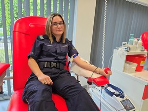 Zdjęcie przedstawia: umundurowana kobietę oddająca krew.