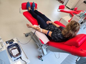 Zdjęcie przedstawia: kobietę, która siedzi na fotelu i oddaje krew.