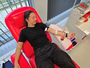 Zdjęcie przedstawia: umundurowaną policjantkę, leżącą na fotelu, w trakcie oddawania krwi.