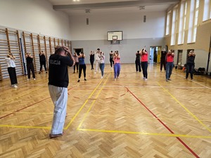 Zdjęcie przedstawia: Policjanta i grupę w trakcie treningu.