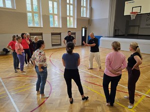 Zdjęcie przedstawia: policjanta i grupę ustawioną przed nim.