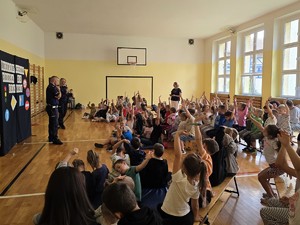 Zdjęcie przedstawia: umundurowanych policjantów podczas pogadanki.