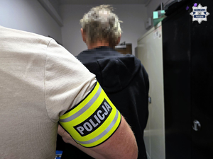 Zdjęcie przestawia zatrzymanego mężczyznę, który stoi tyłem.