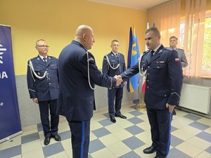 zdjęcie przedstawia: dwóch policjantów podających sobie rękę.