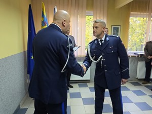 zdjęcie przedstawia: policjanta wraz z komendantem uściskając sobie rękę.