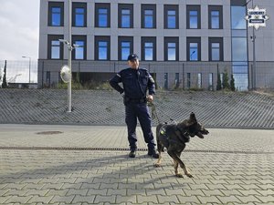 Zdjęcie przedstawia przewodnika psa służbowego oraz psa.