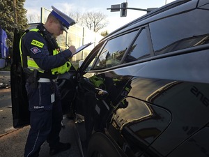 Zdjęcie przedstawia umundurowanego policjanta na miejscu zdarzenia.