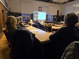 Zdjęcie przedstawia: seniorów i policjanta podczas pogadanki.