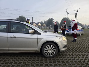 Zdjęcie przedstawia uczestników akcji oraz samochód osobowy.