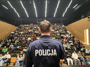 Zdjęcie przedstawia uczestników wydarzenia oraz umundurowanego policjanta.