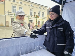 Zdjęcie przedstawia umundurowaną policjantkę oraz uczestników wydarzenia.