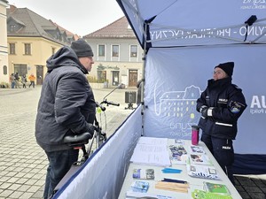 Zdjęcie przedstawia uczestników wydarzenia oraz umundurowaną policjantkę.