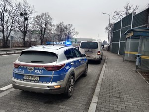 Zdjęcie przedstawia policyjny radiowóz i zatrzymany pojazd.