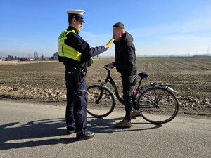 Na zdjęciu znajduje się umundurowany policjant oraz osoba z rowerem.