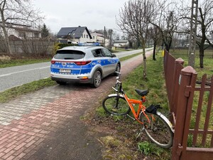 Rower obok oznakowanego radiowozu.