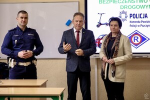 Na zdjęciu znajdują się dwie osoby oraz umundurowany policjant.