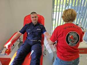 Zdjęcie przedstawia umundurowanego policjanta oddającego krew.
