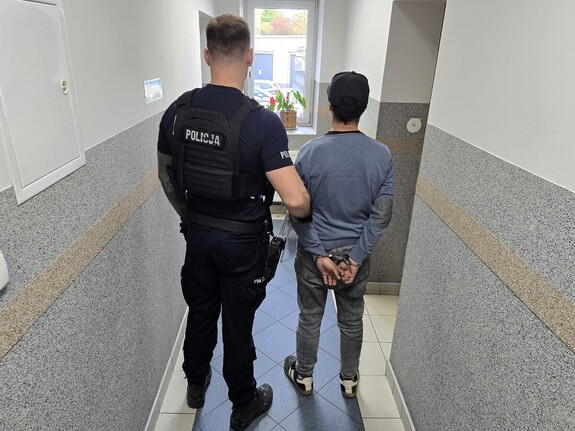 Zdjęcie: policjant z zatrzymanym mężczyzną.