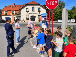 Zdjęcie przedstawia policjanta podczas prelekcji z dziećmi.