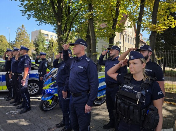 Zdjęcie przedstawia policjantów oddających honor.
