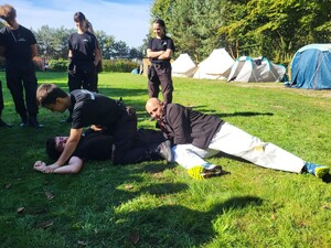 Zdjęcie przedstawia uczniów klasy policyjnych podczas zajęć z policjantem.