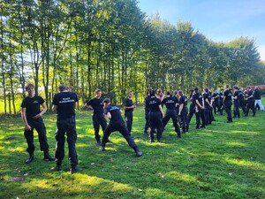 Zdjęcie przedstawia uczniów klasy policyjnych podczas zajęć z policjantem.