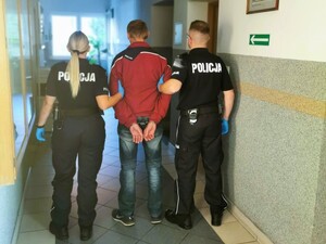 Zdjęcie przedstawia policjanta z zatrzymanym mężczyzną.